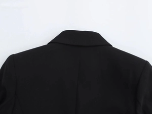 Close-up of the rear collar and shoulder stitching on a black blazer dress