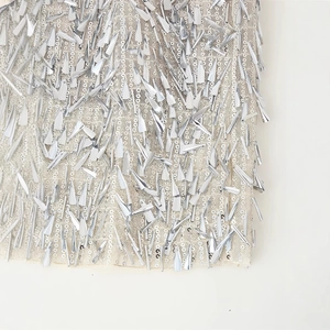 Elegant high-waist mini skirt with silver sequins and metallic fringe details