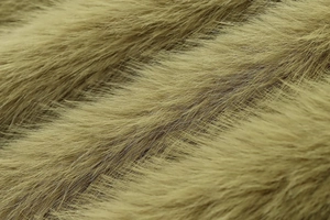Détail macro de la texture de fourrure synthétique vert olive de la veste femme
