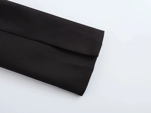 Detailed macro view of black textured fabric sleeve cuff with high-quality stitching