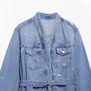 Light blue denim jacket with V-neck cross-over front and belted waist with distressed details
