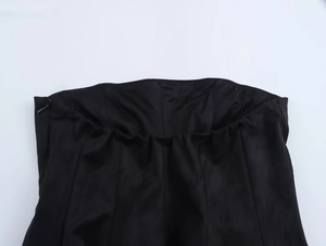 Close-up of the concealed side zipper and waistband texture on the black mini skirt