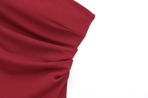 Detail of wine red fabric showing elegant ruched pleated design and woven texture