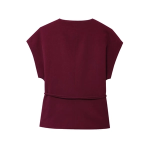 Detail of burgundy sleeveless knit top featuring side tie waist and textured fabric