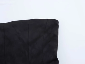 Detailed macro view of black strapless top featuring suede texture and structural boning seams