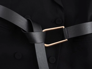 Close-up of black leather waist belt with elegant gold rectangular buckle on blazer