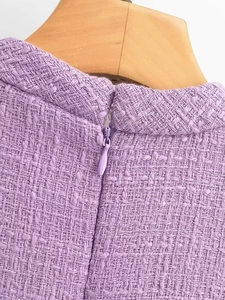 Détail de robe en tweed violet avec fermeture éclair invisible et tissage de haute qualité
