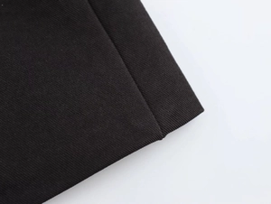 Close-up of black twill fabric texture showing premium stitching and structured material