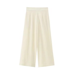 Detailed view of cream-colored wide-leg trousers with vertical pleats and high-waist design