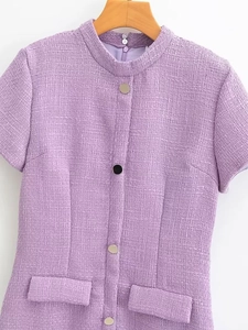 Détail du tissu en tweed lilas avec boutons métalliques et poches décoratives de la robe