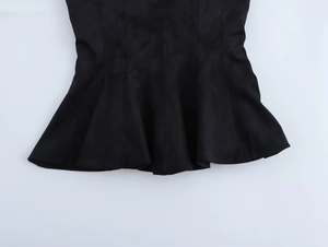 Detailed macro view of the ruffled hem on black suede texture tube top with neat stitching