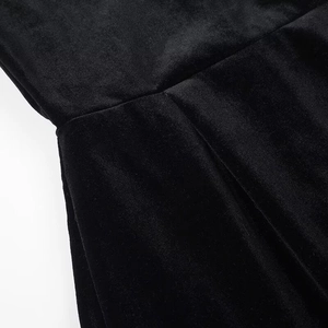 Detailed macro view of black velvet fabric stitching and soft texture on the dress