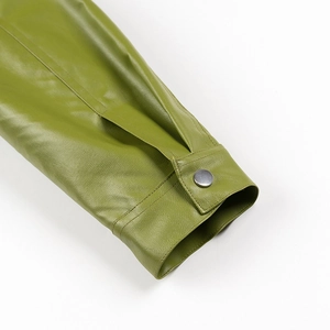 Close-up of avocado green faux leather jacket cuff with silver metal button and fine stitching