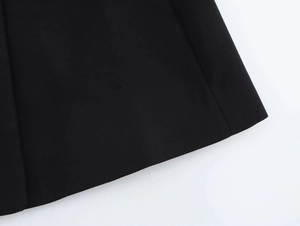 Close-up of premium black fabric texture and neat stitching on dress hemline