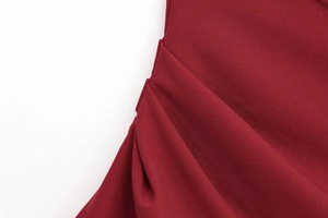 Close-up of wine red ruched blouse showing detailed pleats and woven fabric texture