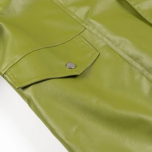 Detailed macro view of green PU leather texture with flap pocket and silver metal button