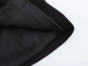 Detail shot of the black blazer dress showing premium stitching and silky inner lining