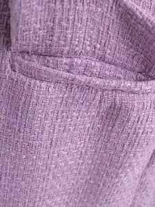 Gros plan détaillé sur la texture en tweed violet et la finition de la poche de la robe