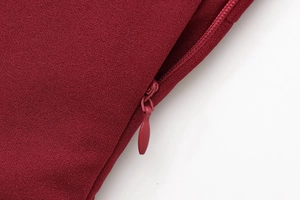 Detailed close-up of invisible zipper and woven texture on burgundy asymmetric top