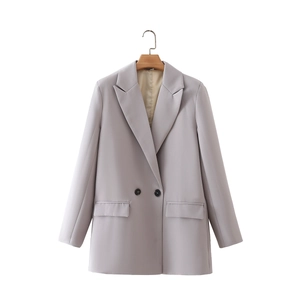 Detailed view of women's double-breasted blazer with notched lapel and flap pockets