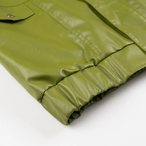 Detail of green faux leather jacket featuring a snap-button flap pocket and elastic hem
