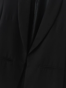 Detailed close-up of notched lapel and high-quality fabric texture on black blazer jacket