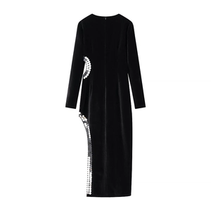 Détail d'une robe noire moulante avec fente latérale et ornements de paillettes argentées