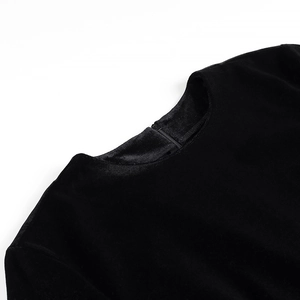 Gros plan d'une robe en velours noir avec col rond élégant et fermeture éclair invisible