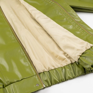Detail of green faux leather jacket showing beige lining, metal zipper and elastic hem