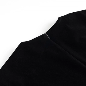 Détail d'une fermeture éclair invisible sur une robe en velours noir à texture lisse