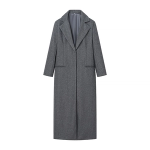 Dettaglio di un cappotto di lana grigio scuro con trama del tessuto raffinata e tasche classiche
