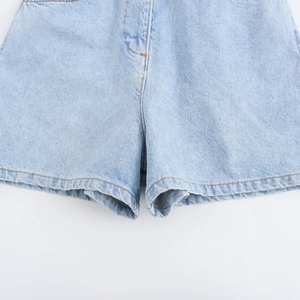 Dettaglio ravvicinato del tessuto denim azzurro con cuciture arancioni a contrasto