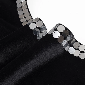 Détail de la robe en velours noir avec bordure de paillettes argentées et texture douce