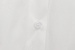 Detailed macro view of high-quality white cotton fabric and transparent round buttons