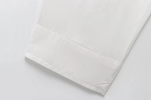 Close-up of white cotton shirt cuff with neat stitching and premium fabric texture