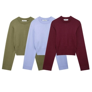 Detail of ribbed cuffs and necklines on olive, blue, and red cropped knit sweaters