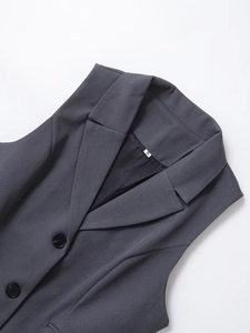 Close-up of the notched lapel and size S tag on a grey sleeveless suit vest for women