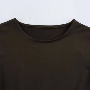 Detailed view of the dark round neckline and fine knit fabric of this bodysuit