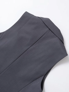 Detail of dark grey vest showing back stitching and twill fabric texture on white background