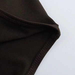 Close-up of overlock stitching detail on coffee brown knitted slim bodysuit fabric