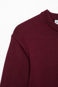 Detail of burgundy knitted sweater showing round ribbed neckline and fine texture