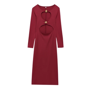 Détail de la robe bordeaux à manches longues avec découpes et boucles en métal doré