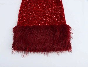 Detailed close-up of vibrant red sequins and faux fur trim on the party dress hemline