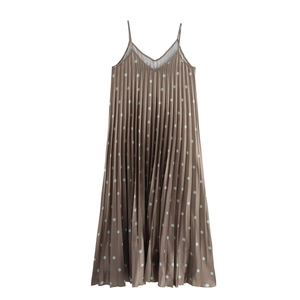 Détail d'une robe marron plissée à pois montrant des textures d'accordéon verticales
