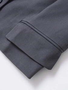 Detail of grey sleeveless vest showing premium twill fabric texture and fine sewing craftsmanship
