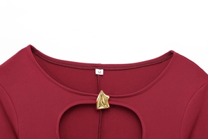 Détail du col en U de la robe rouge avec découpe et attache métallique dorée