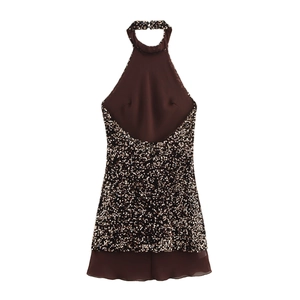 Close-up detail of sequined halter neck dress with layered chiffon hem in brown gold