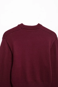 Detailed close-up of wine red crewneck knit sweater showcasing fine fabric texture