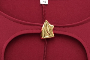 Détail de l'encolure robe bordeaux avec découpe et boucle métallique dorée géométrique