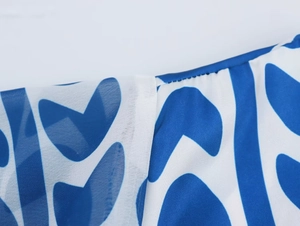Dettaglio della stampa a cuori blu su tessuto bianco con cuciture rifinite bene